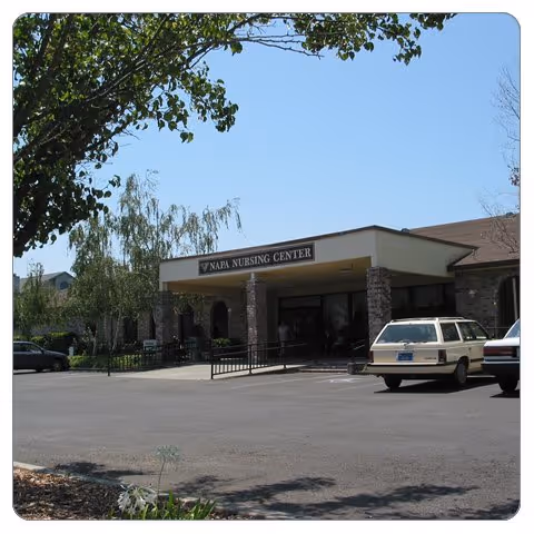 Napa Nursing Center entrance with parked cars and trees.
