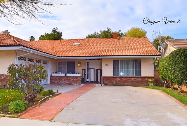 Front exterior of Canyon View Residential Care Facility, single-story with red tile roof and driveway.