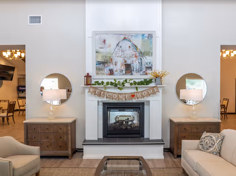 Cozy living room with fireplace, welcome banner, two side tables, and sofas.