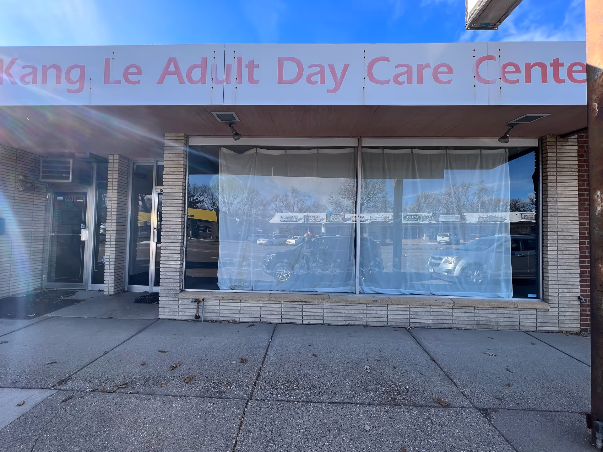 Storefront of Kang Le Adult Day Care Center with large front window and sign.