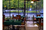 Interior dining room with green tablecloths and a large window view.