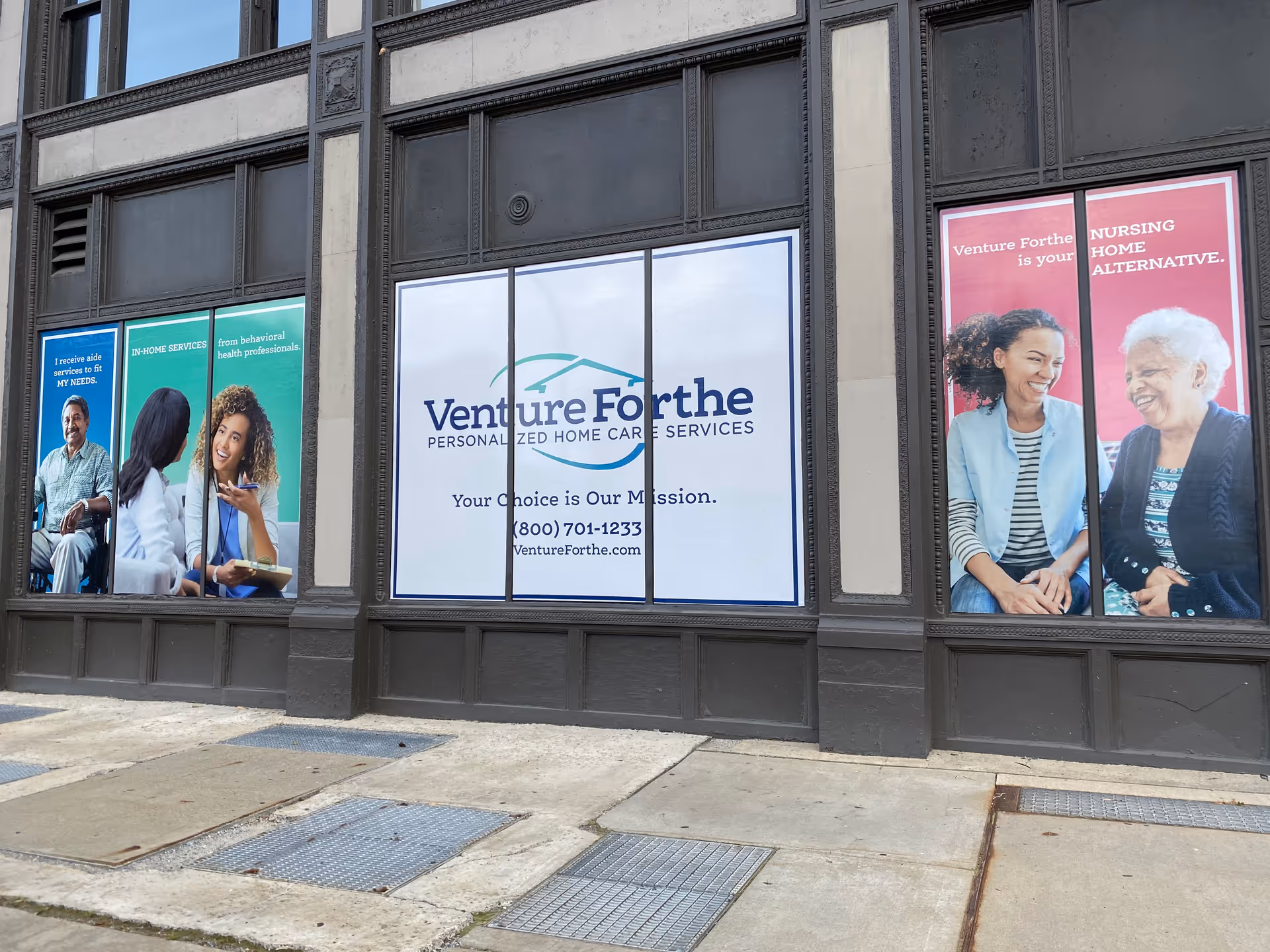 Facade of a building with large windows displaying Venture Forthe home care banners.