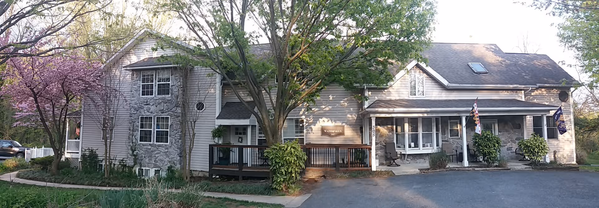Exterior view of Waterfalls of Catonsville Memory Care Home with trees and entrance
