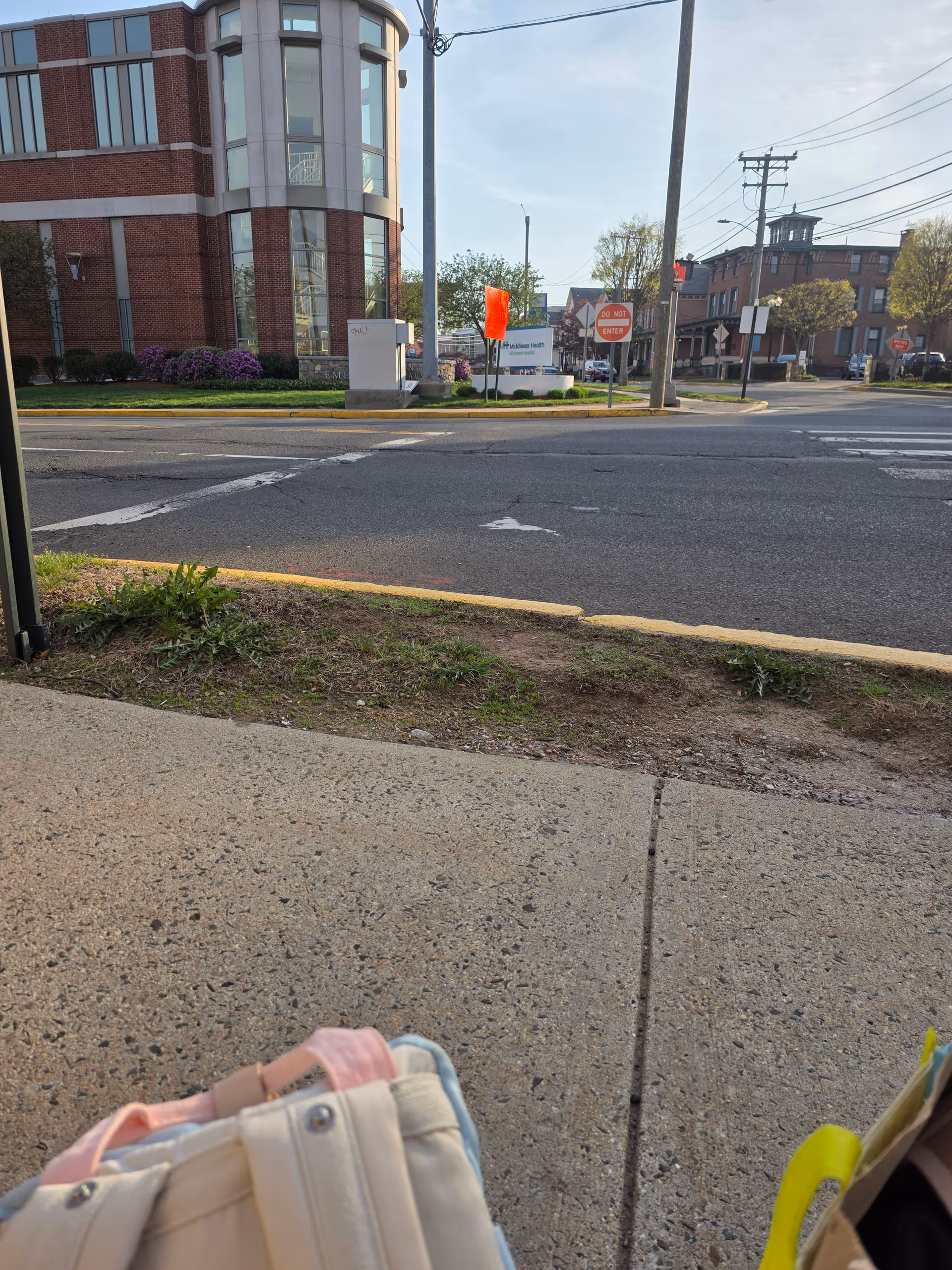 Exterior view of Middlesex Hospital building by a street, with sidewalk and cars.