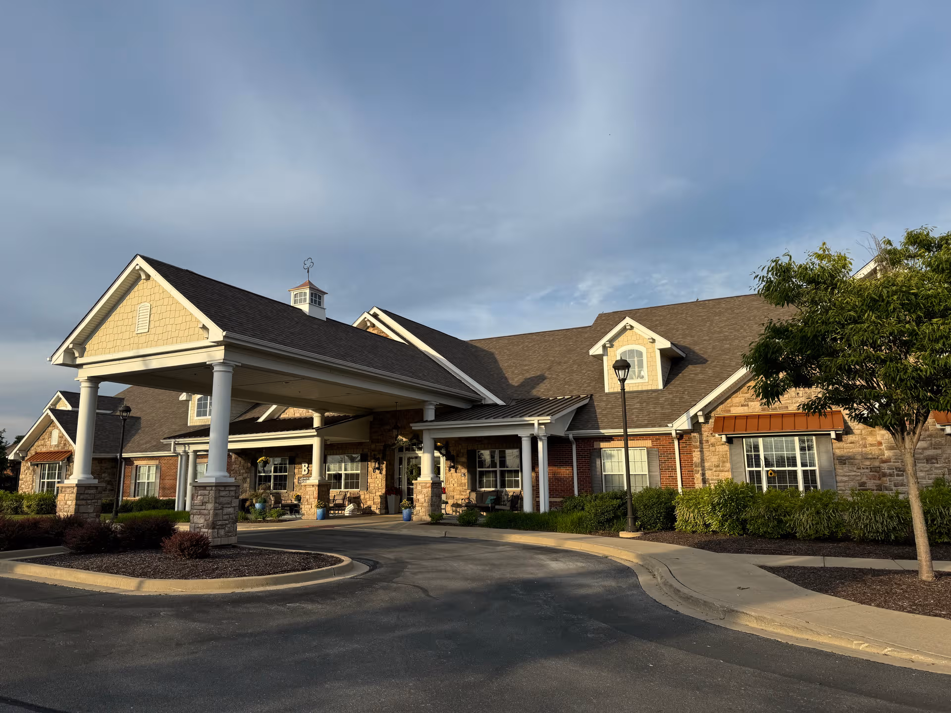 Exterior view of a Bickford of Tinley Park building with a covered entrance and landscaping.