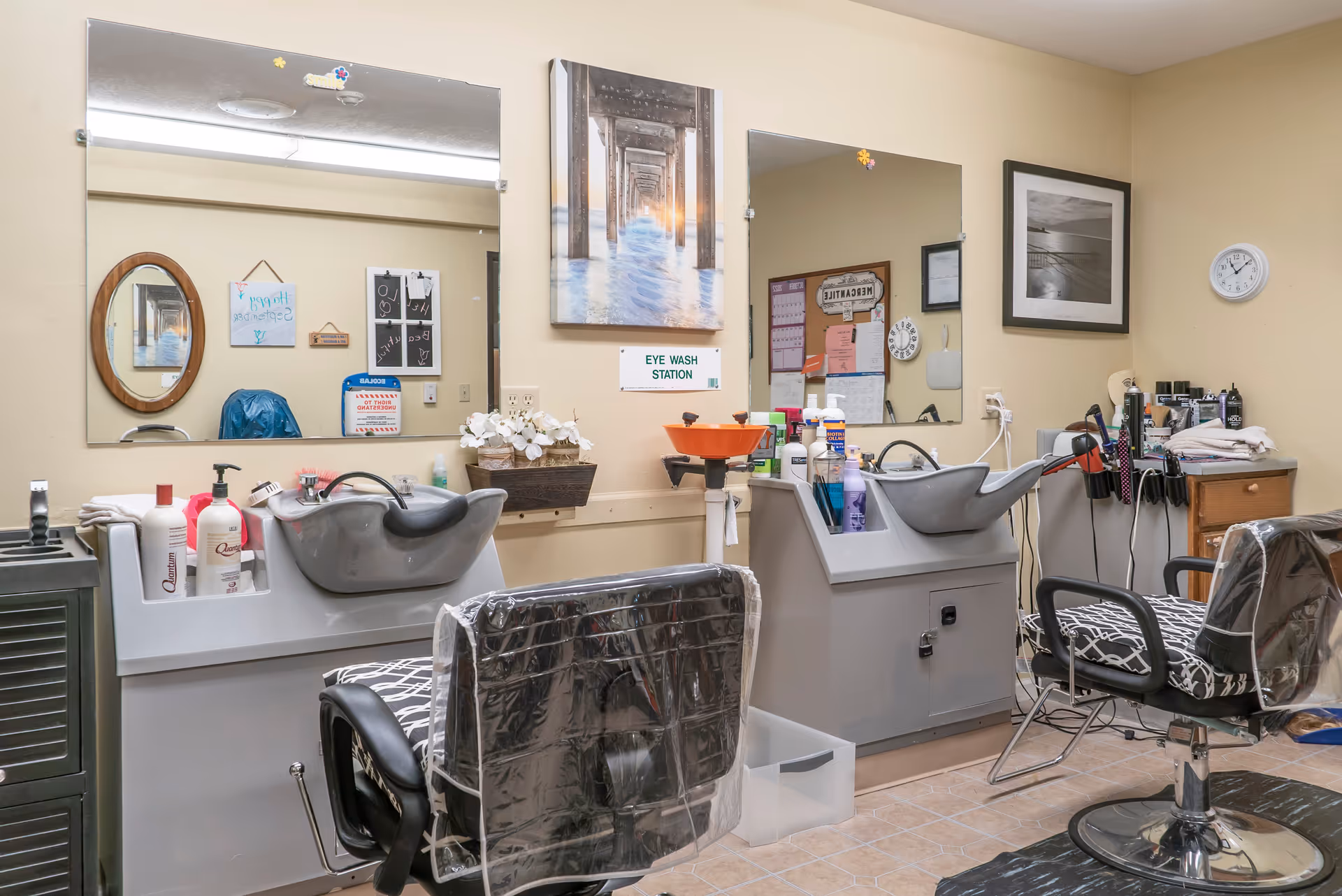 Interior salon with two hair-washing stations, salon chairs, mirrors, and styling supplies.