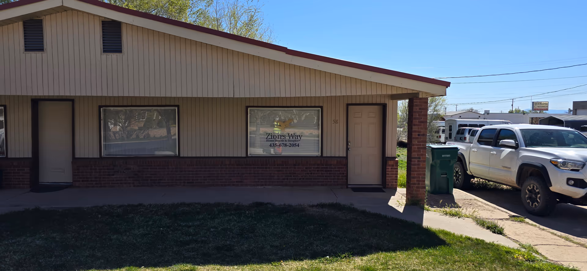 Front exterior of Zion's Way Home Health & Hospice building with parked truck.