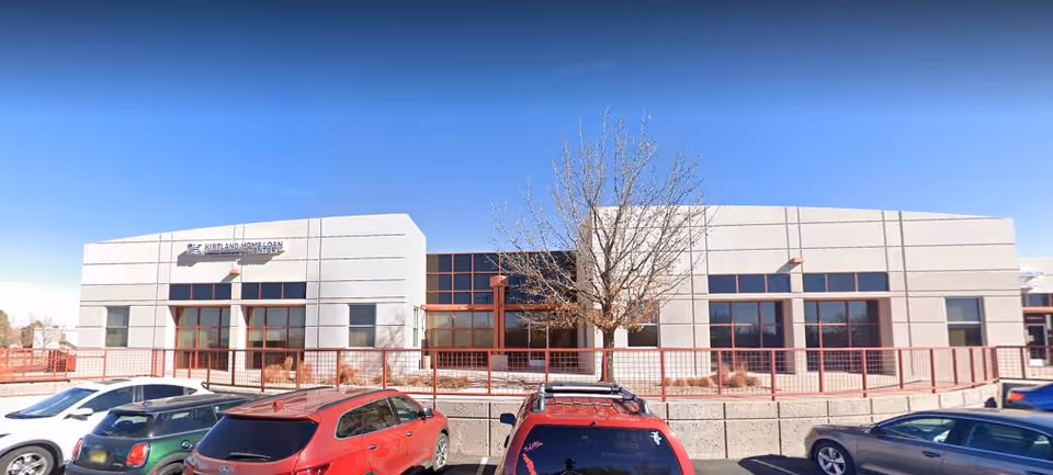Exterior view of CNS Cares senior living facility with a parking lot.