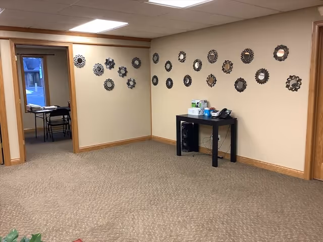 Beige interior lounge with circular wall decor and a black console table.