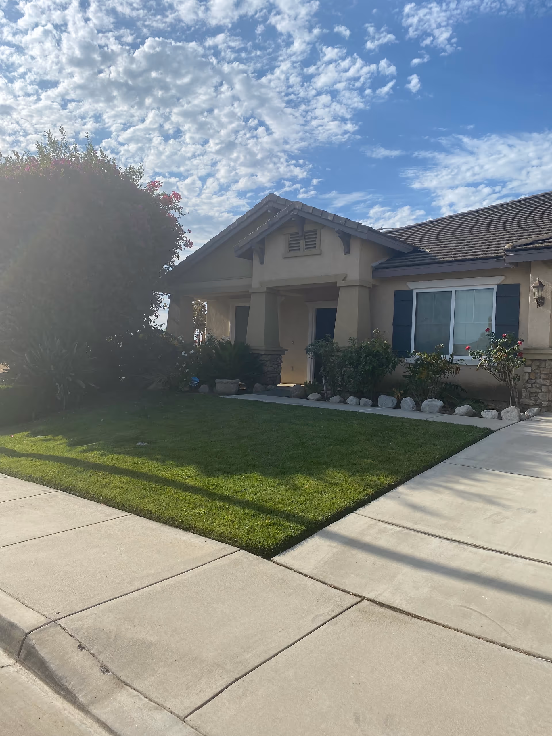 Front view of a single-story Sunset Lamtarra Loop senior living facility with a green lawn.