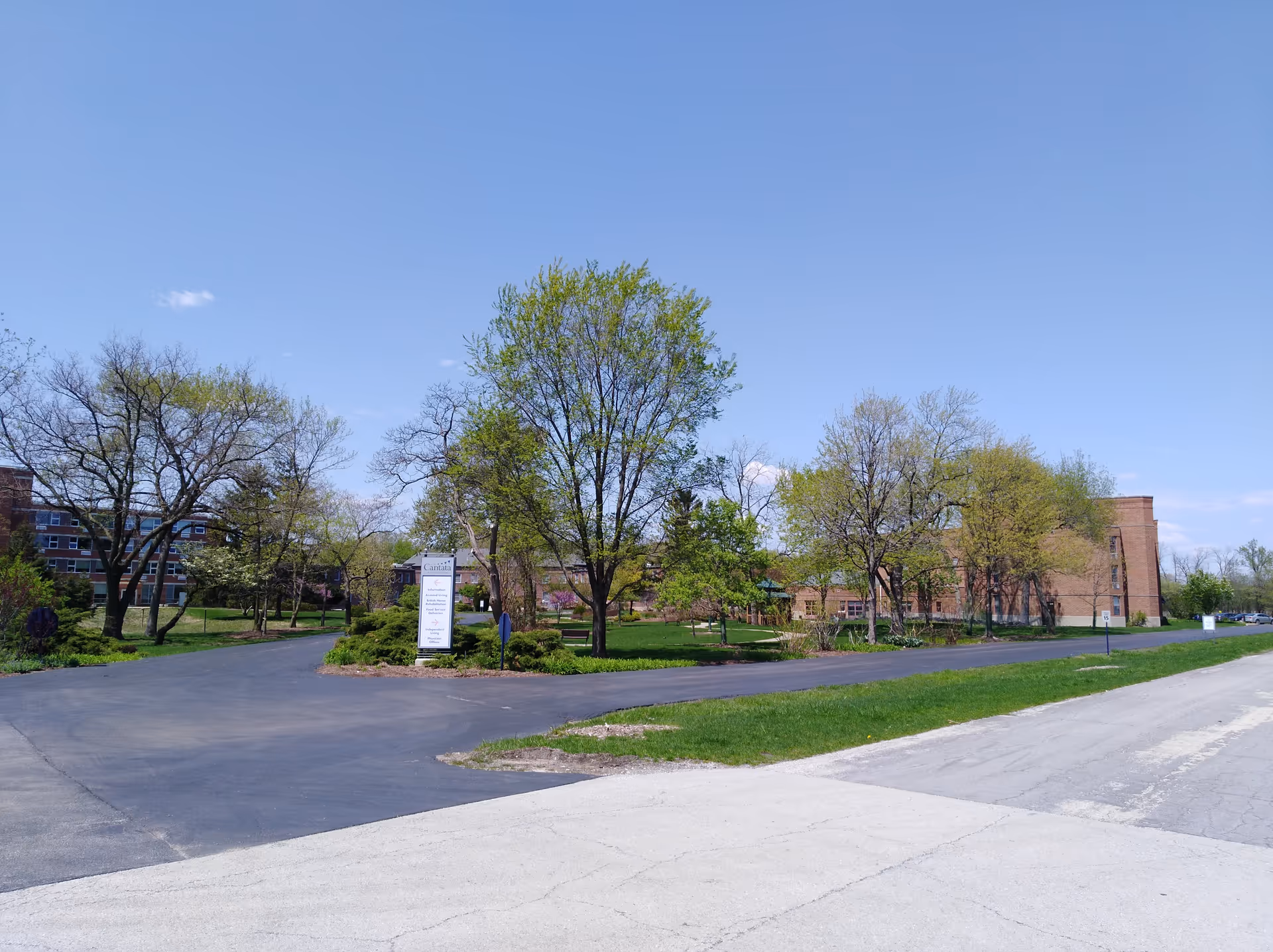 Exterior view of Cantata Adult Life Services campus with trees and parking.