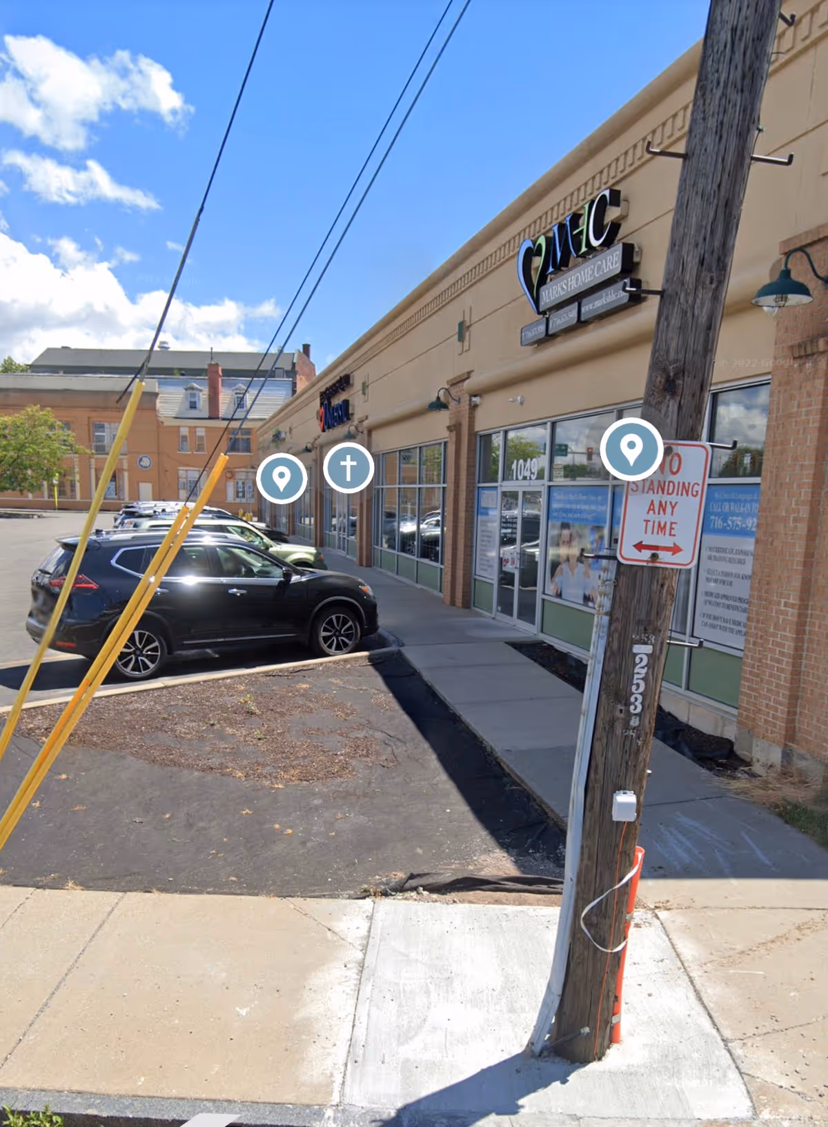 Exterior view of Marks Home Care Agency storefront with parked cars along the sidewalk.
