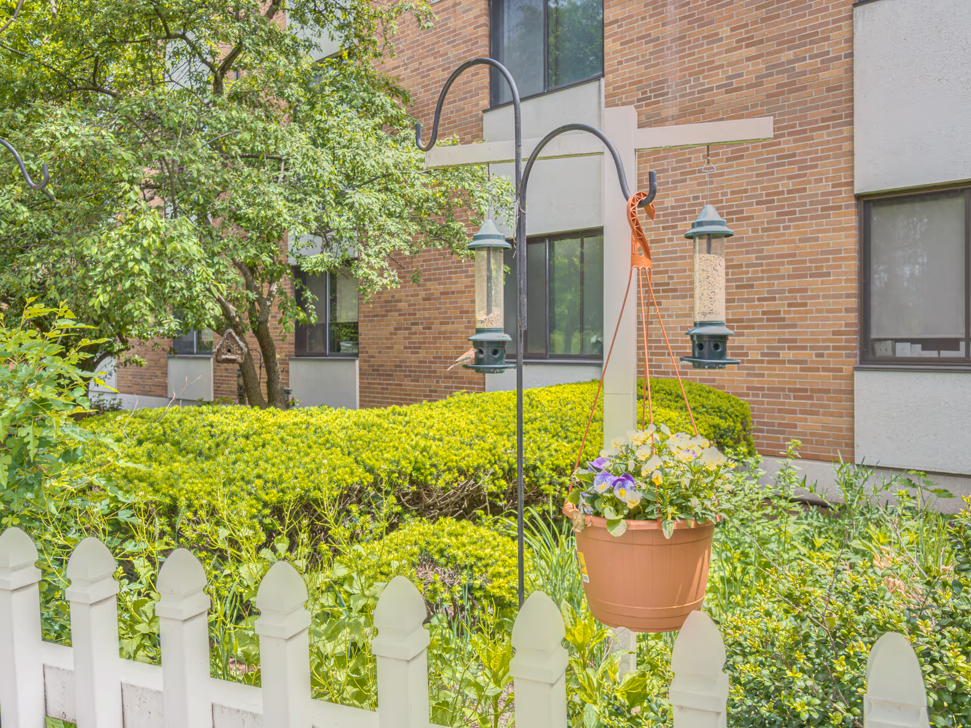 View of MissionCare at Holyoke exterior with hanging planter and white picket fence.