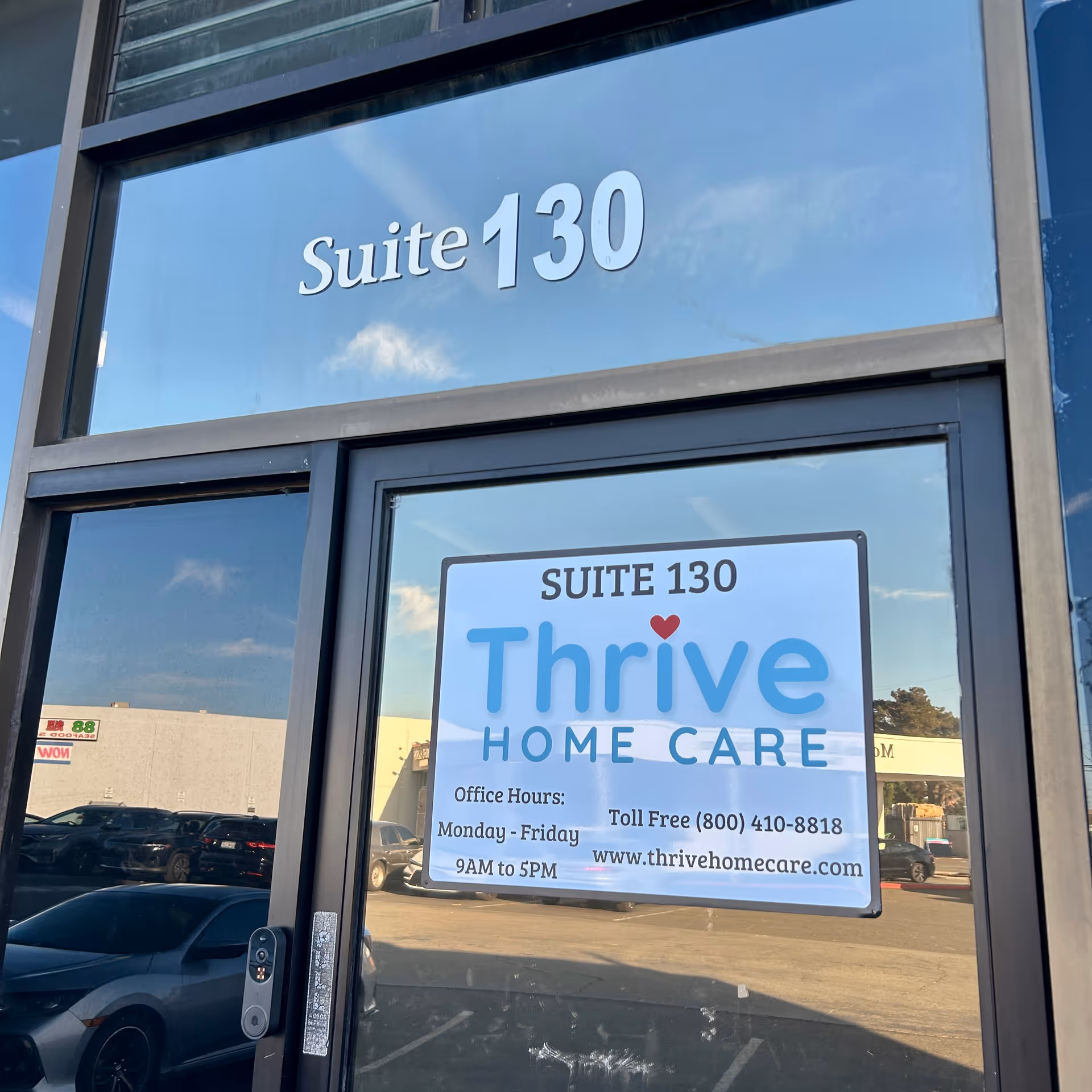 Exterior view of a building entrance with a door sign reading Thrive Home Care Suite 130.