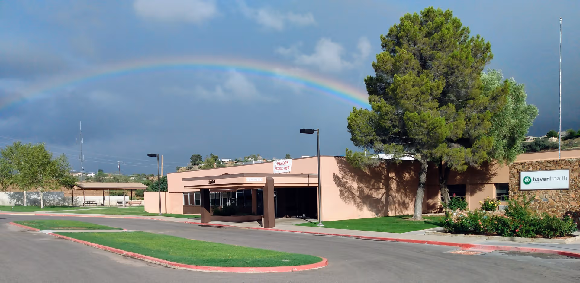 Exterior view of Haven Health Globe facility with rainbow arching over the building.