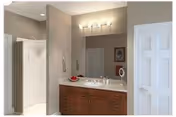Bathroom vanity with sink, mirror, and shower stall in a well-lit room.