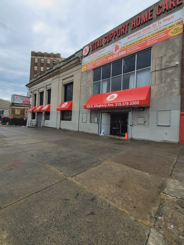 Exterior view of a building with Vital Support Home Care signage and red awnings.