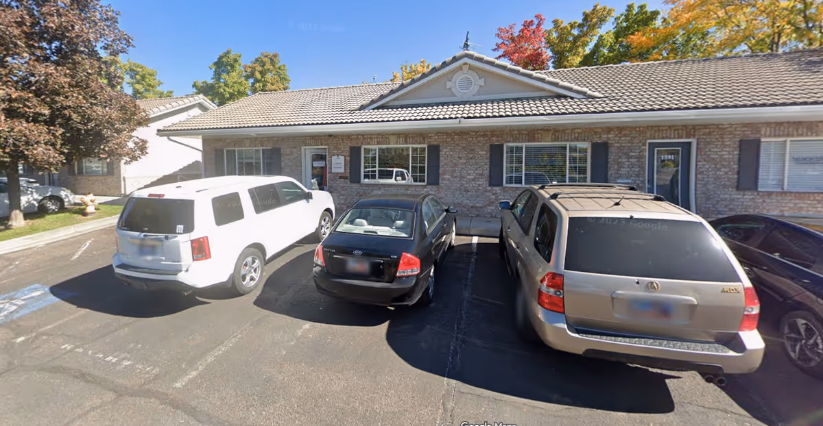 Single-story Aspen Senior Care building with a front parking lot and several cars.