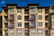 A multi-story beige senior living facility facade with balconies and large windows.