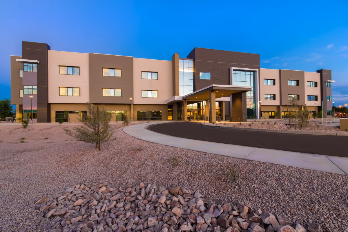 Exterior view of Center at Arrowhead front entrance with curved driveway and desert landscaping.