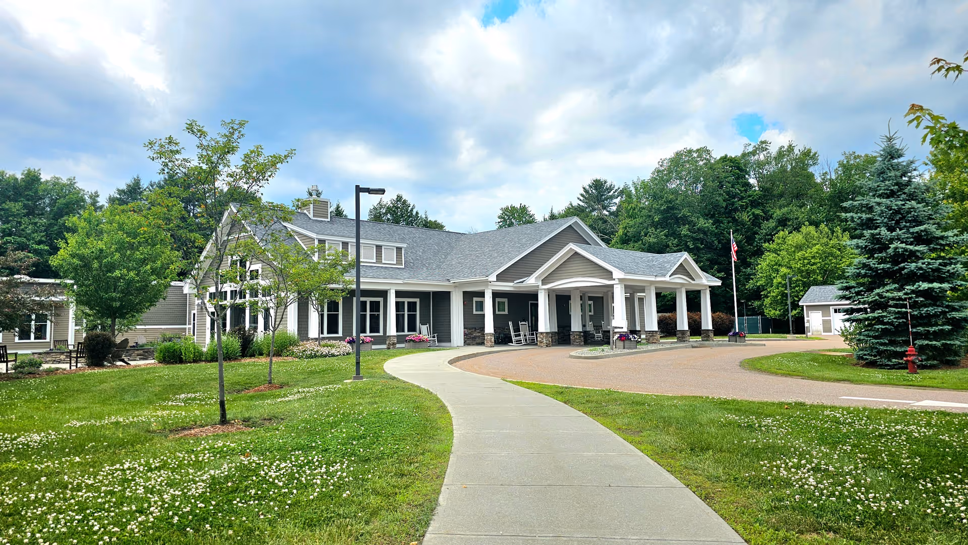 Front exterior of McClure Miller Respite House with curved walkway and manicured lawn
