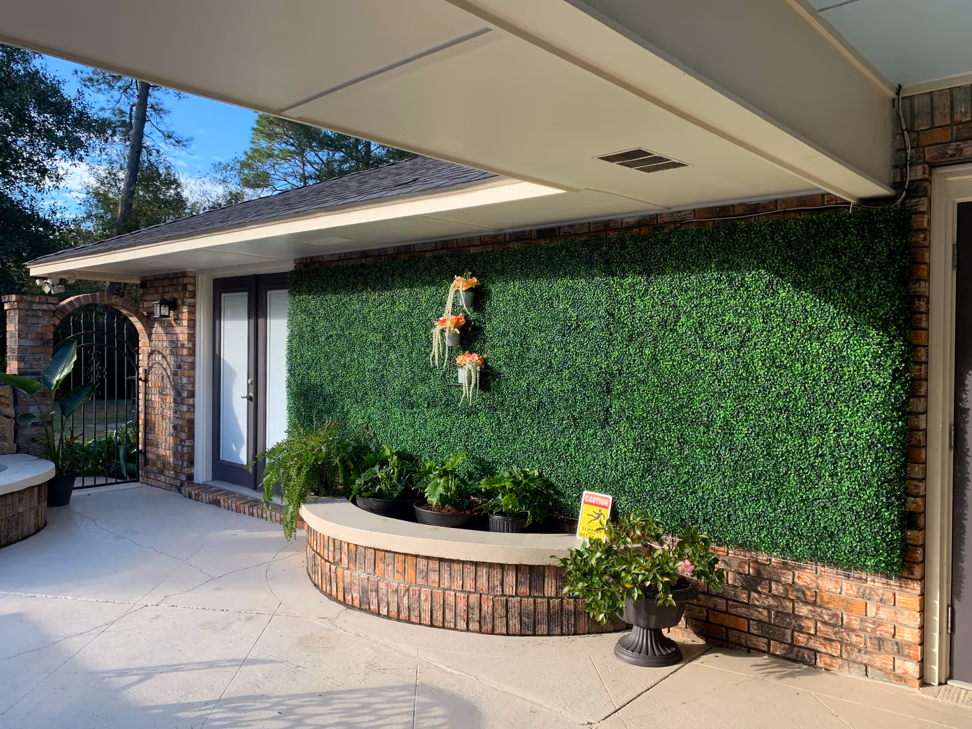 Brick exterior of Angel Oaks with a green living wall and potted plants near the entrance.
