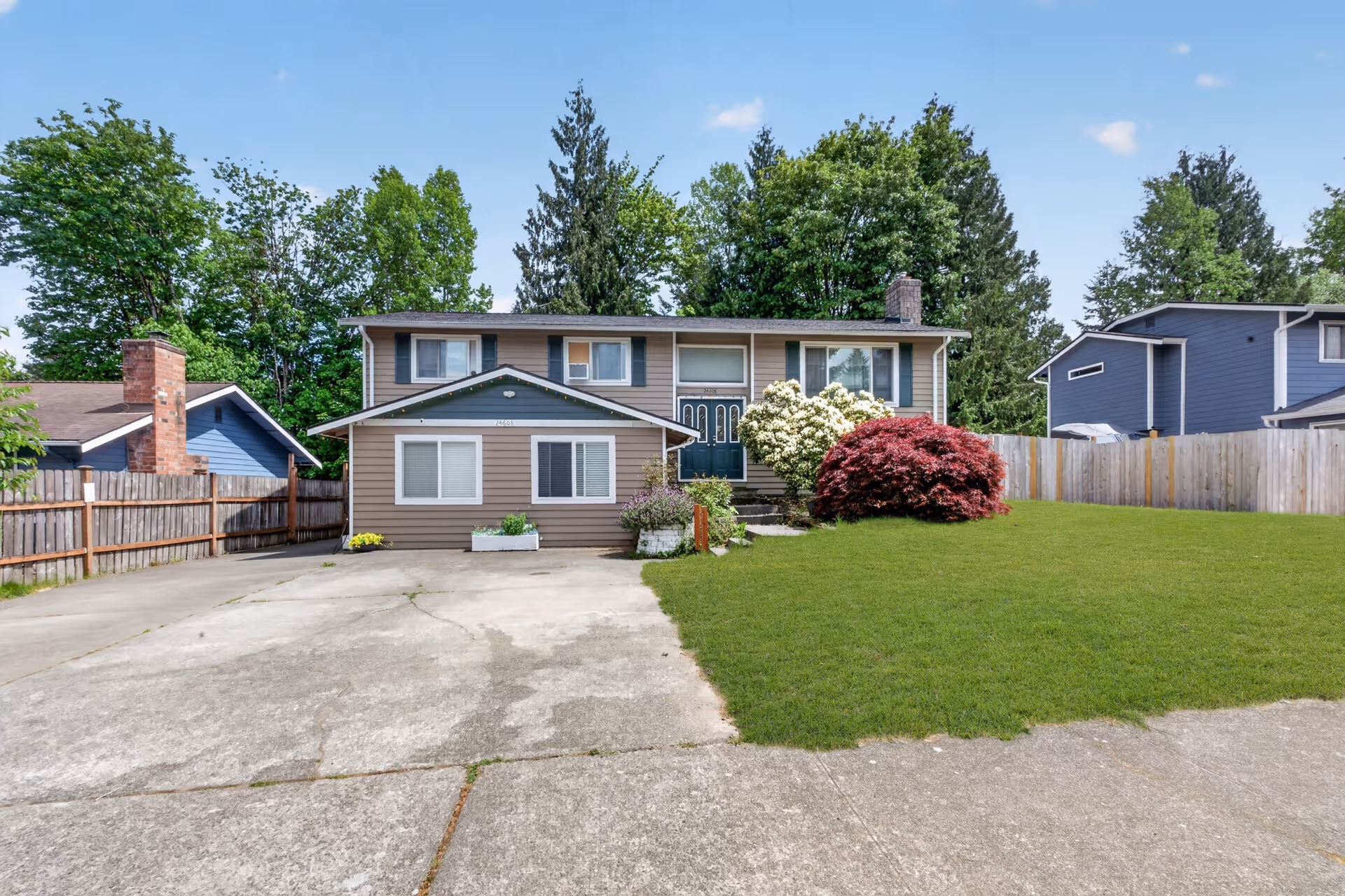 Front view of a two-story home with a green lawn and driveway.