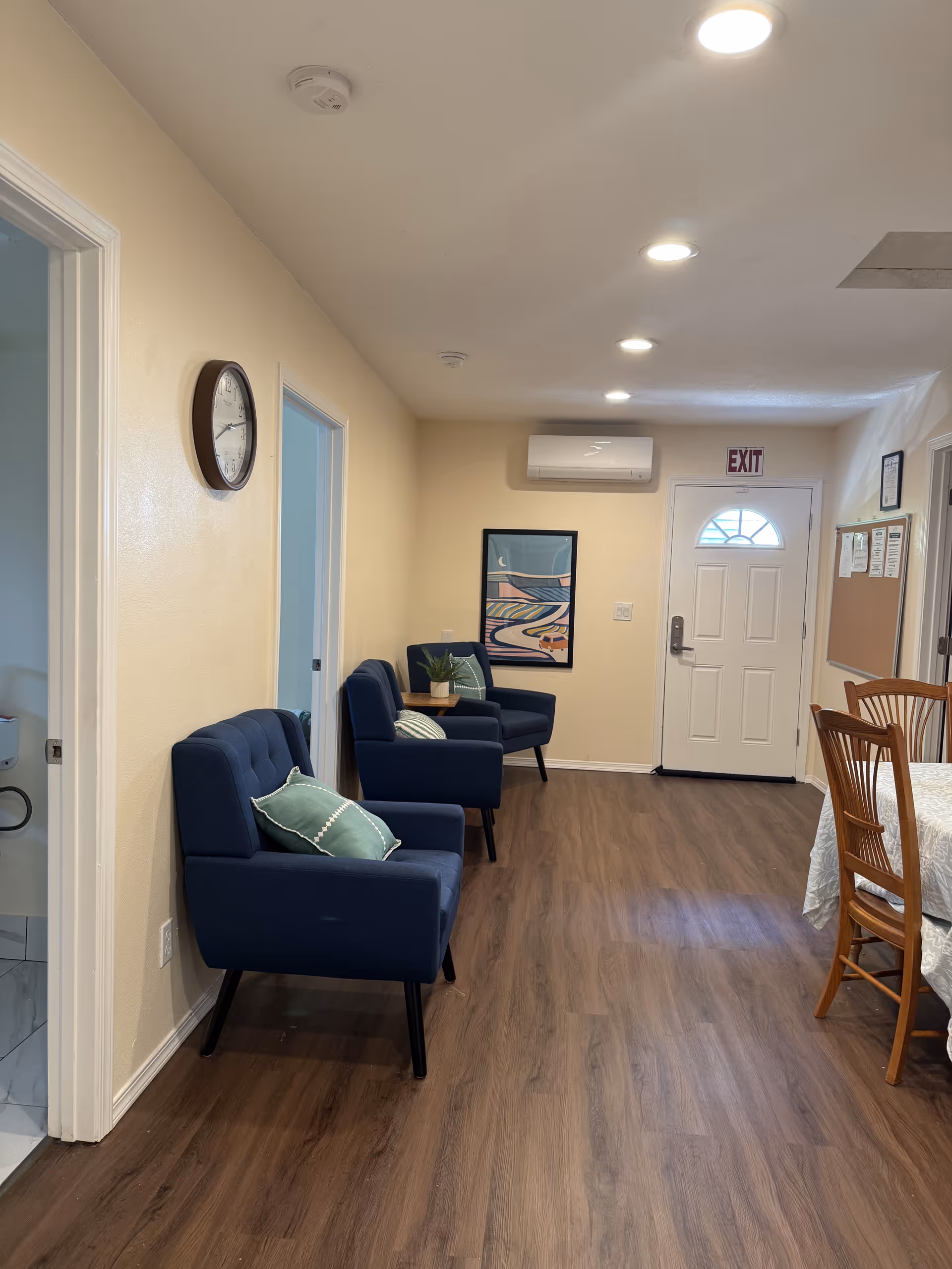 Narrow hallway lounge in Bethlehem adult family home with blue chairs and artwork.