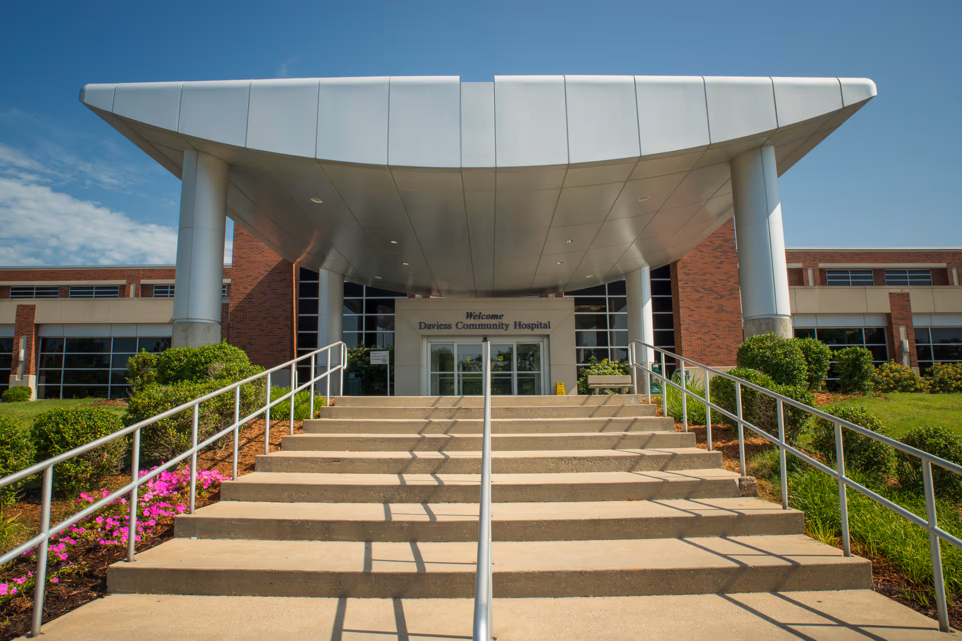 Front entrance of Daviess Community Hospital with wide stairs and curved canopy.