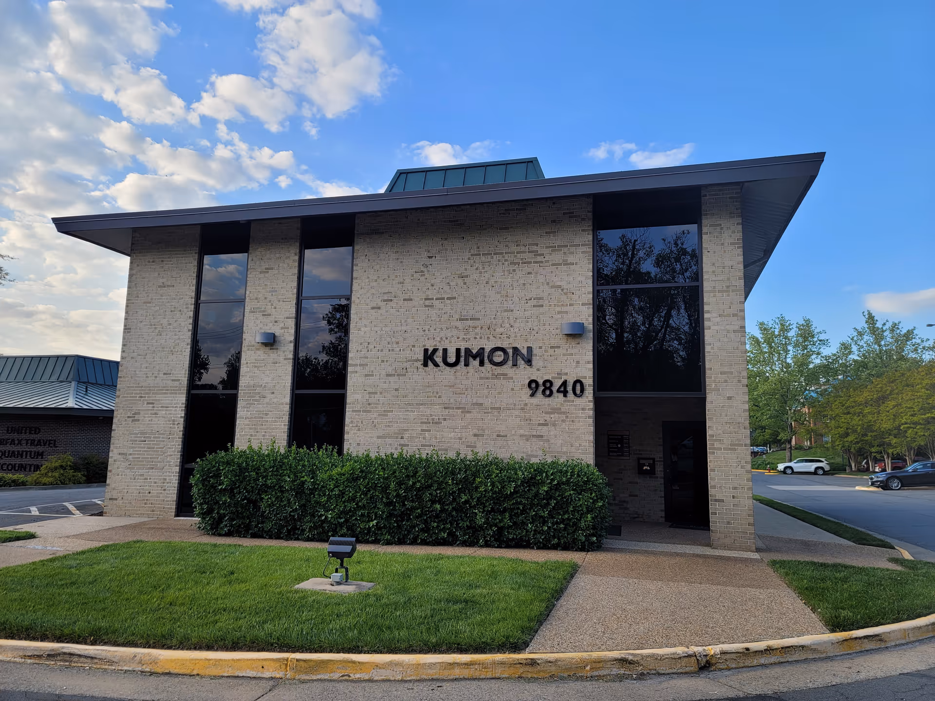Front view of a brick office building with large windows and Kumon signage.