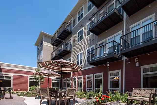 Lighthouse Retirement exterior with balconies and outdoor dining courtyard.