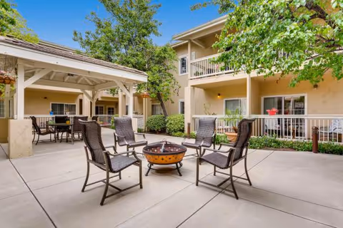 Outdoor courtyard of Somewhere in Time senior living with chairs arranged around a fire pit.