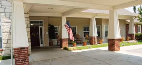 Front entrance of Brookdale Harbison with brick columns, a covered walkway, and an American flag.