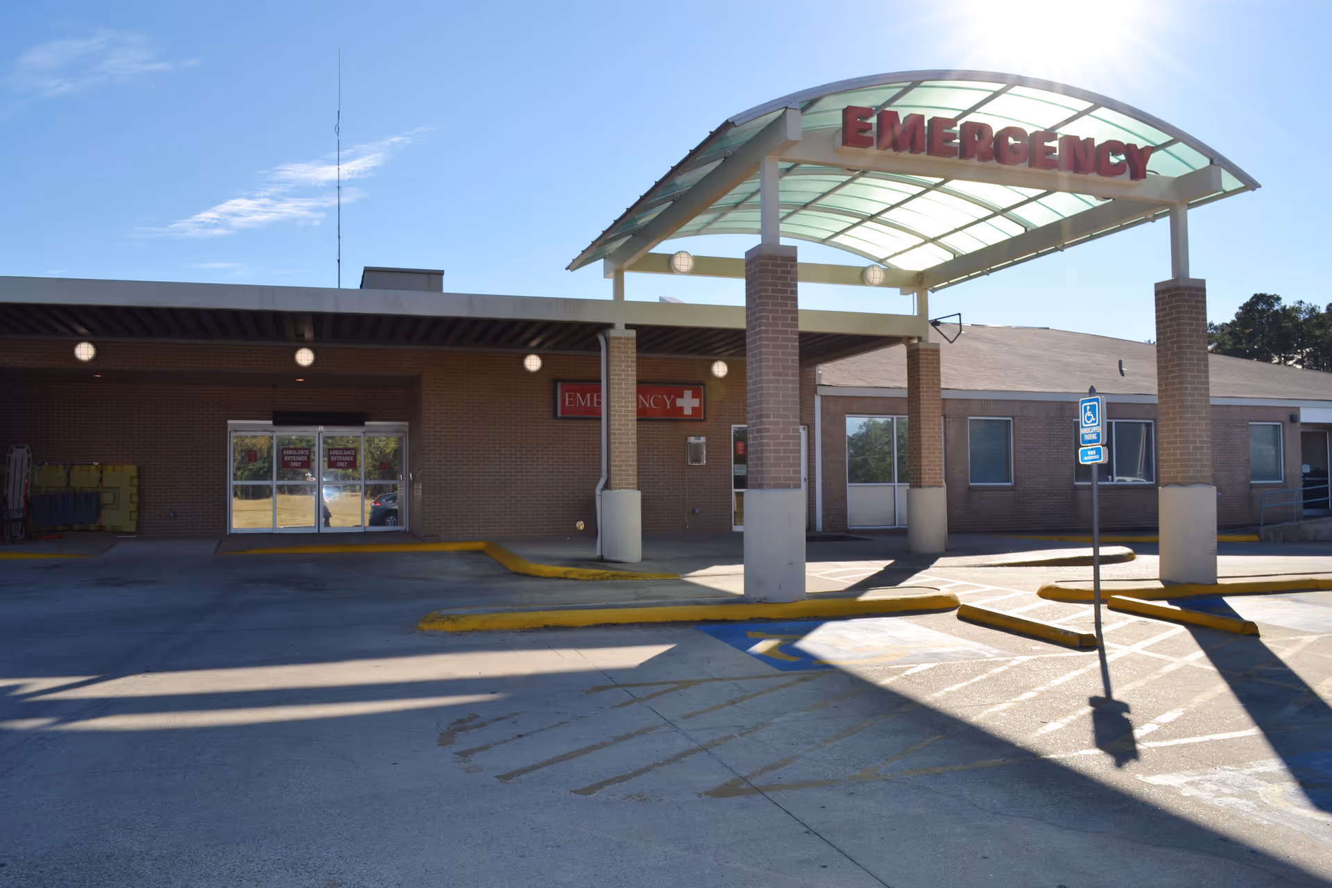 Emergency entrance to a brick health system facility with glass canopy