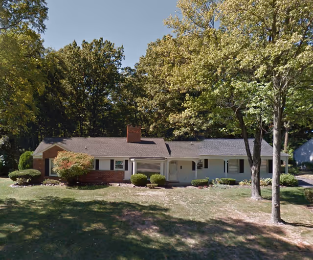 Front view of Chateau of West Bloomfield building with lawn and trees.
