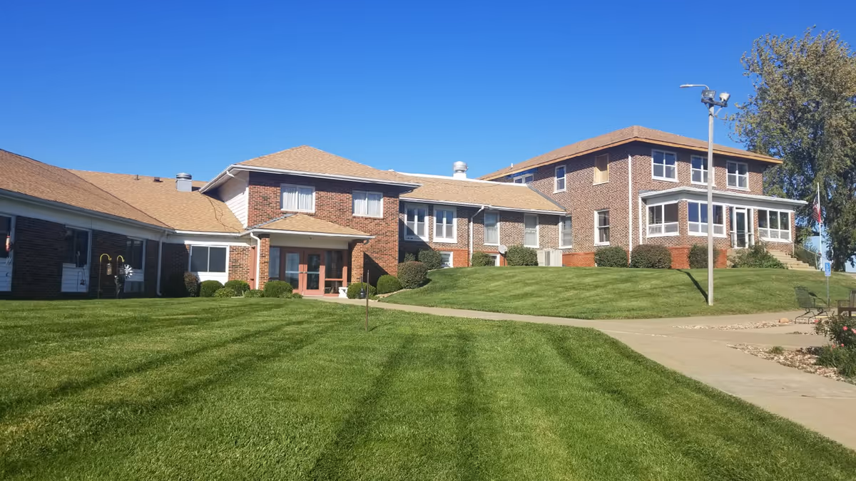 Nodaway Nursing Home exterior with brick buildings and well-kept lawn under blue sky