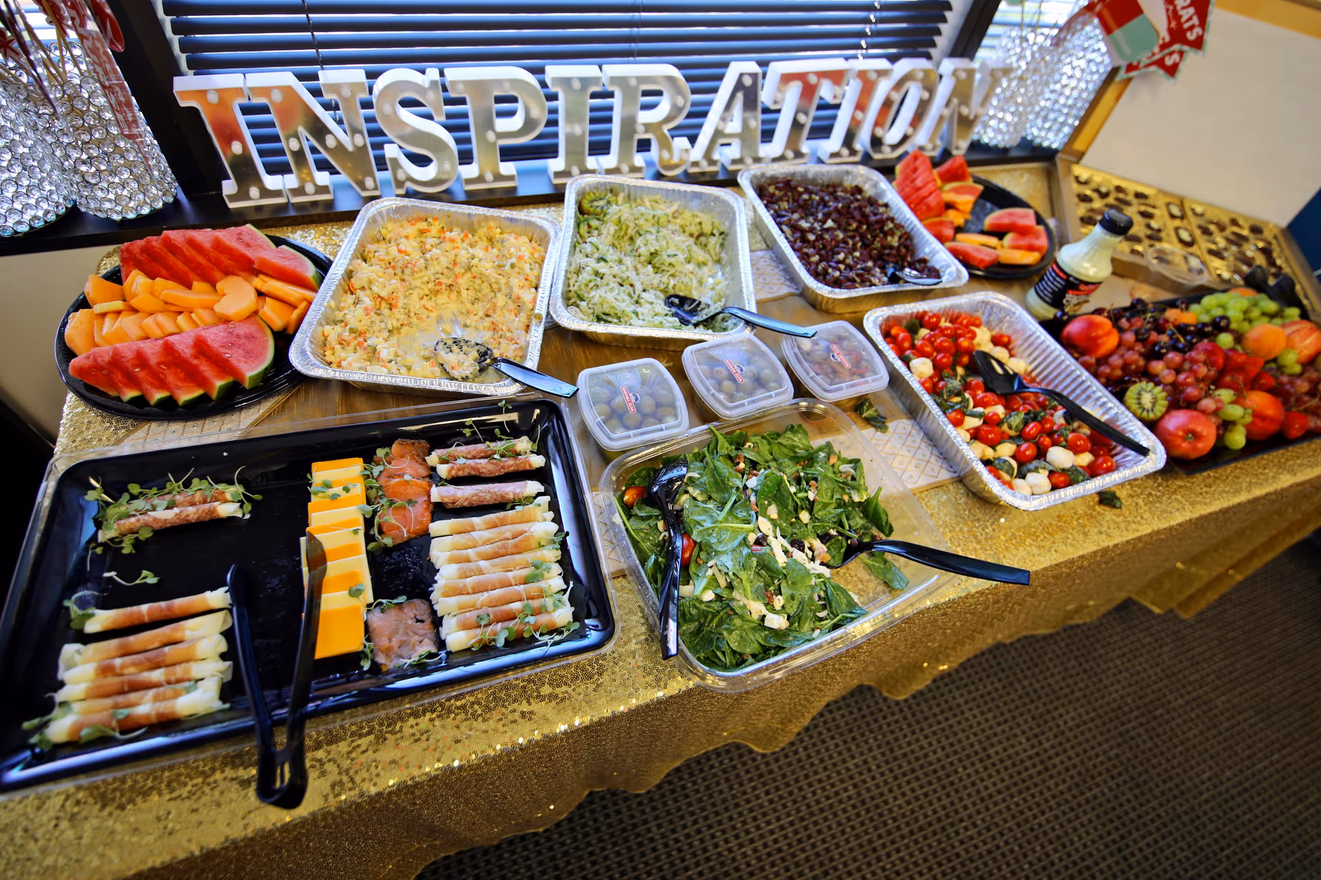 Buffet table laden with salads, fruit, and assorted dishes in a dining area.