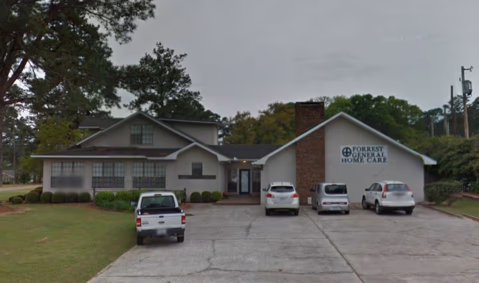 Exterior of Forrest General Home Care building with parked cars.
