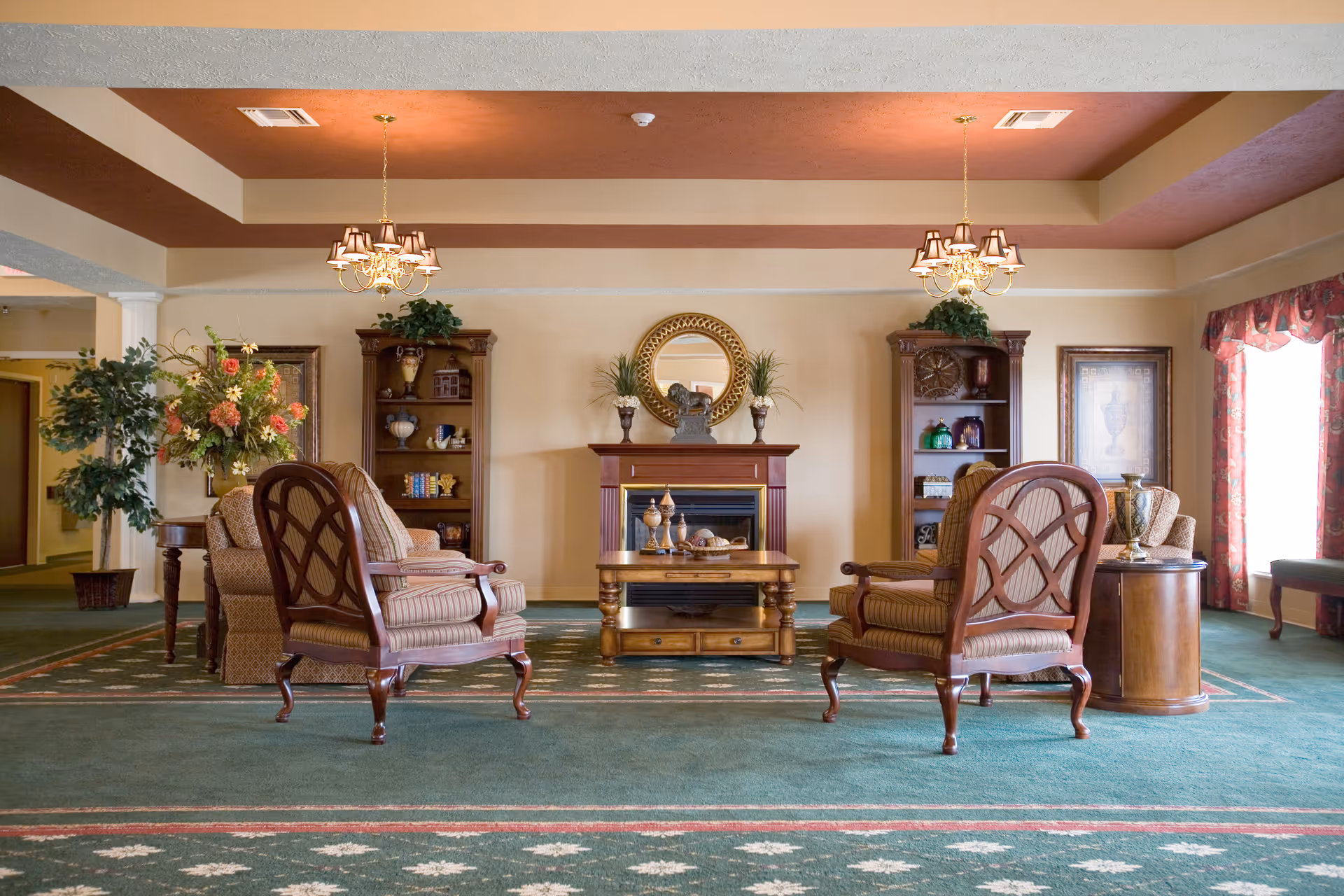 Elegant lounge with upholstered chairs, coffee table, and fireplace.