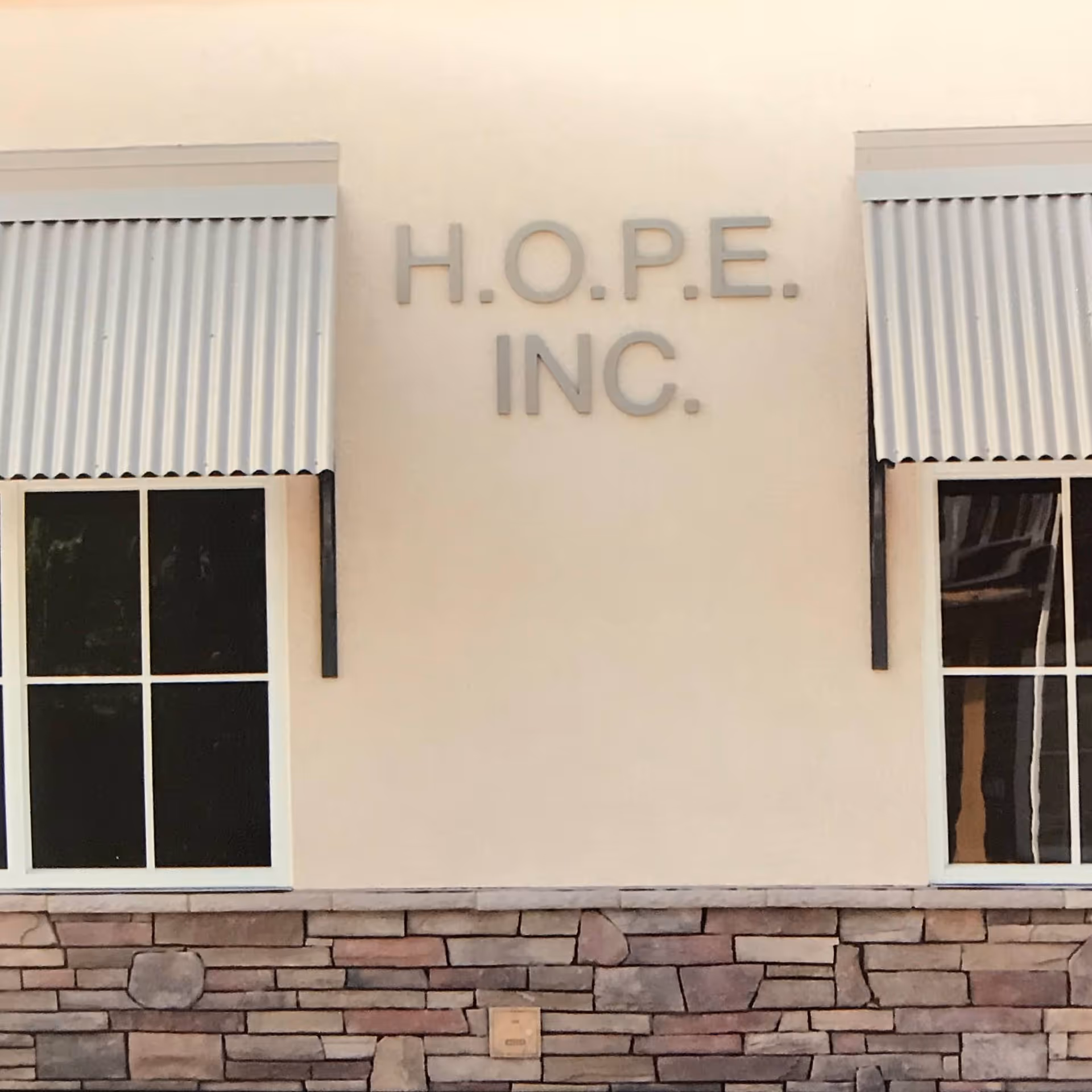 Front exterior of a Hope Homes facility with beige walls and stone base.