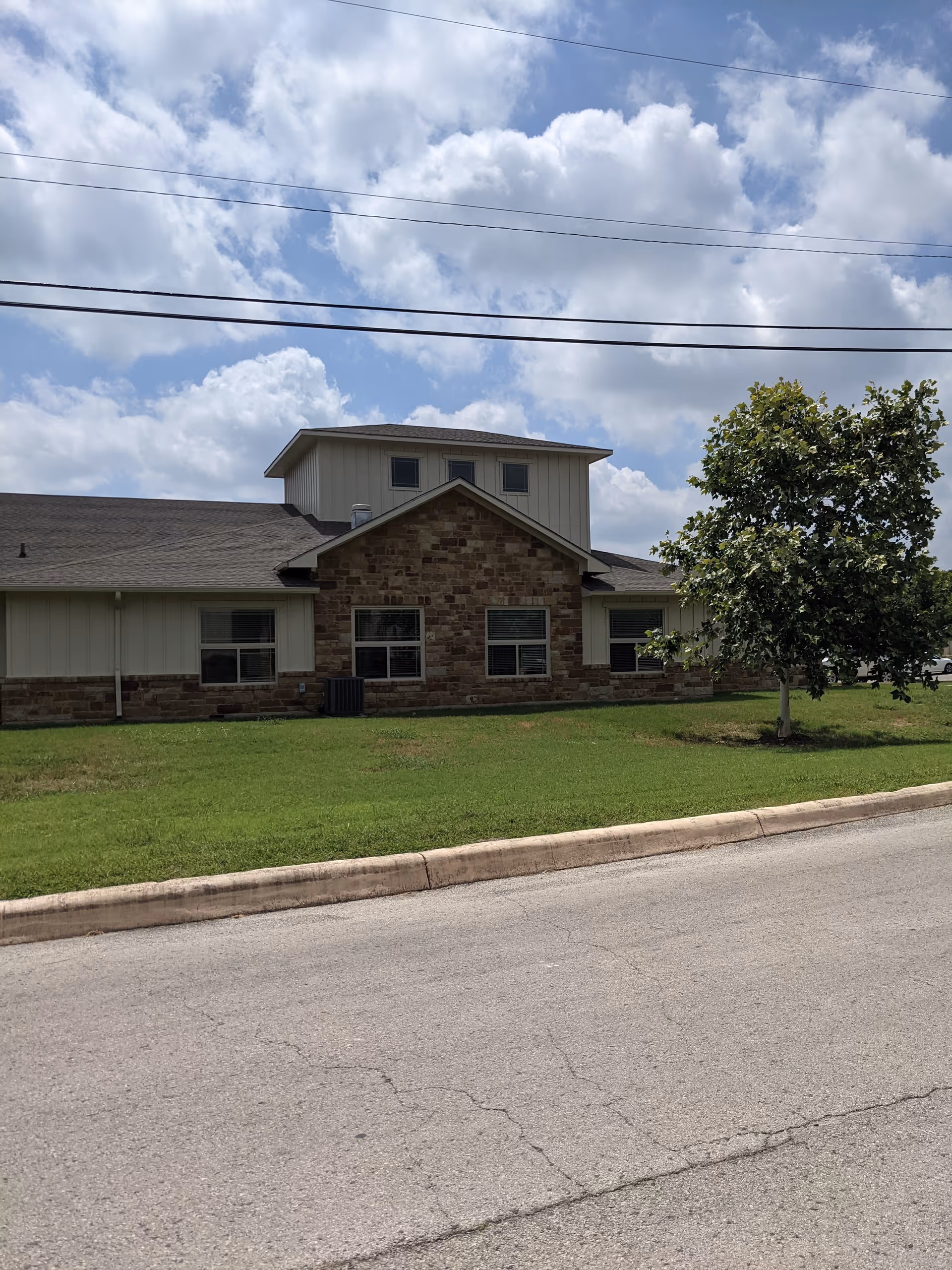 Exterior view of Lakeside Nursing and Rehabilitation Center with brick facade, lawn, and tree.