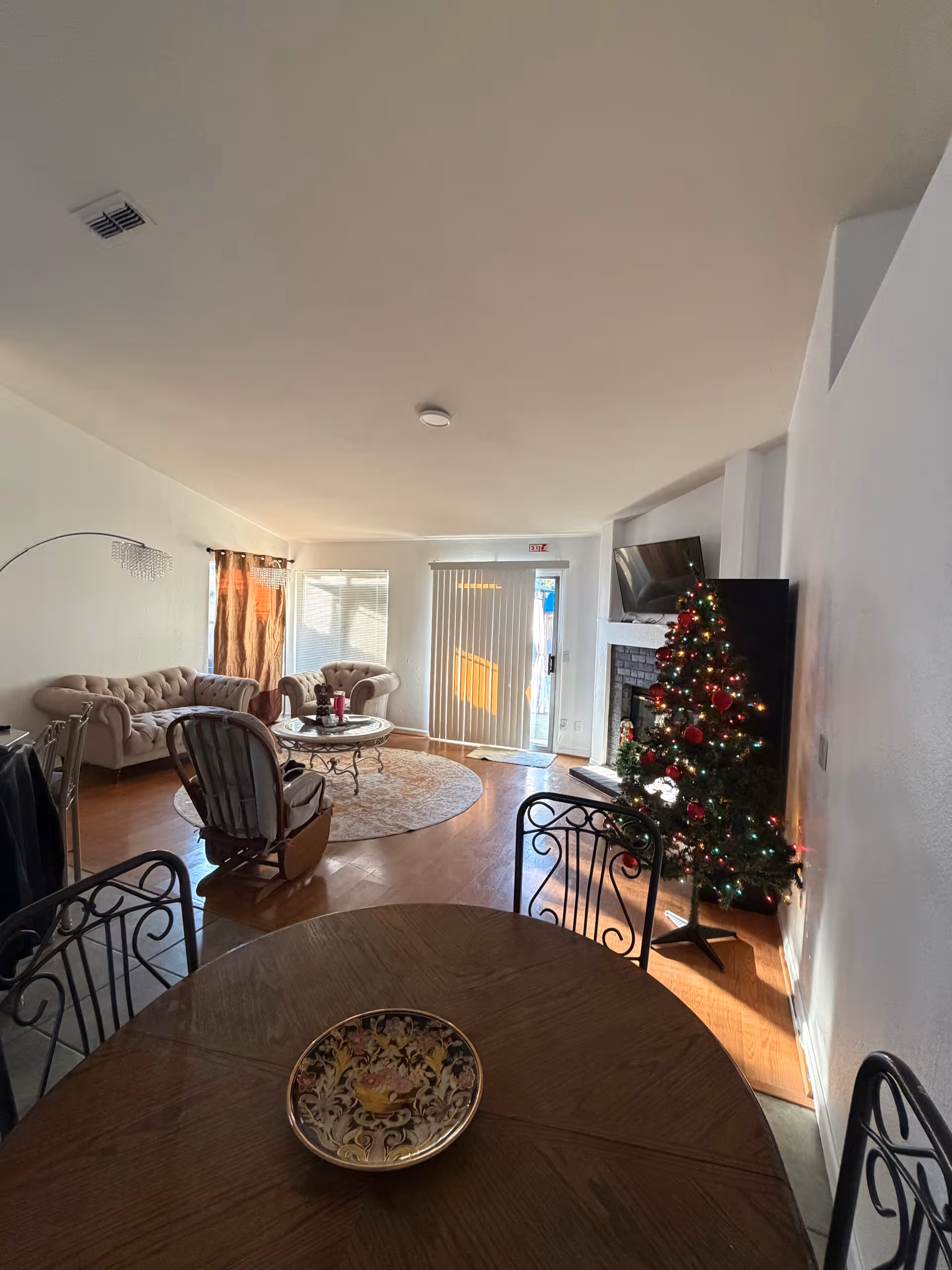 Cozy living room in a senior facility featuring a Christmas tree, fireplace, and seating area.