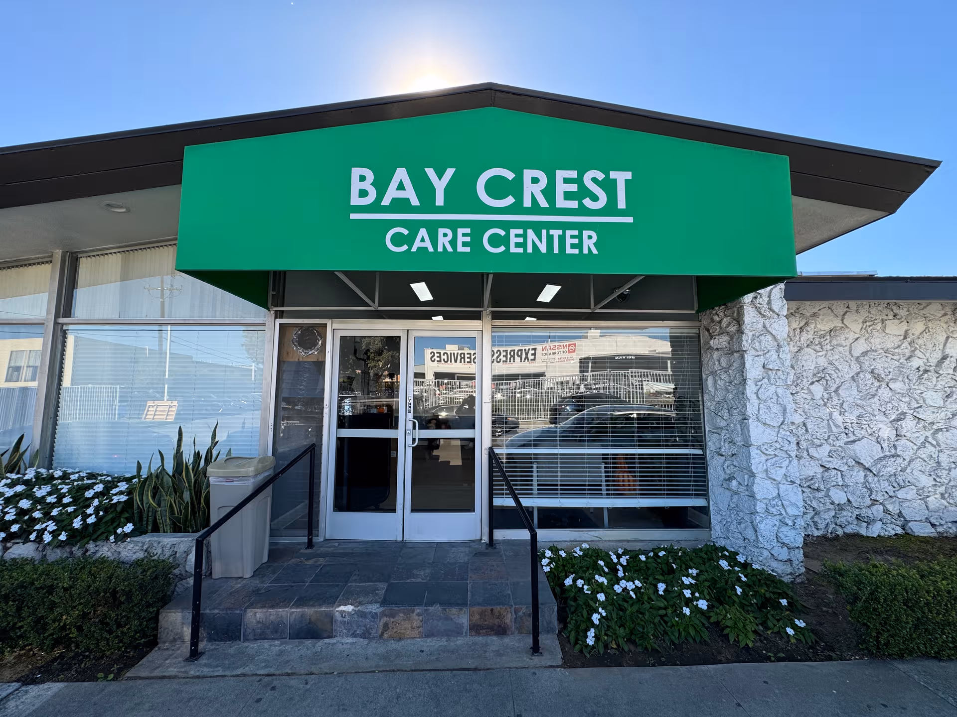 Front entrance of Bay Crest Care Center, with a green sign above doors.