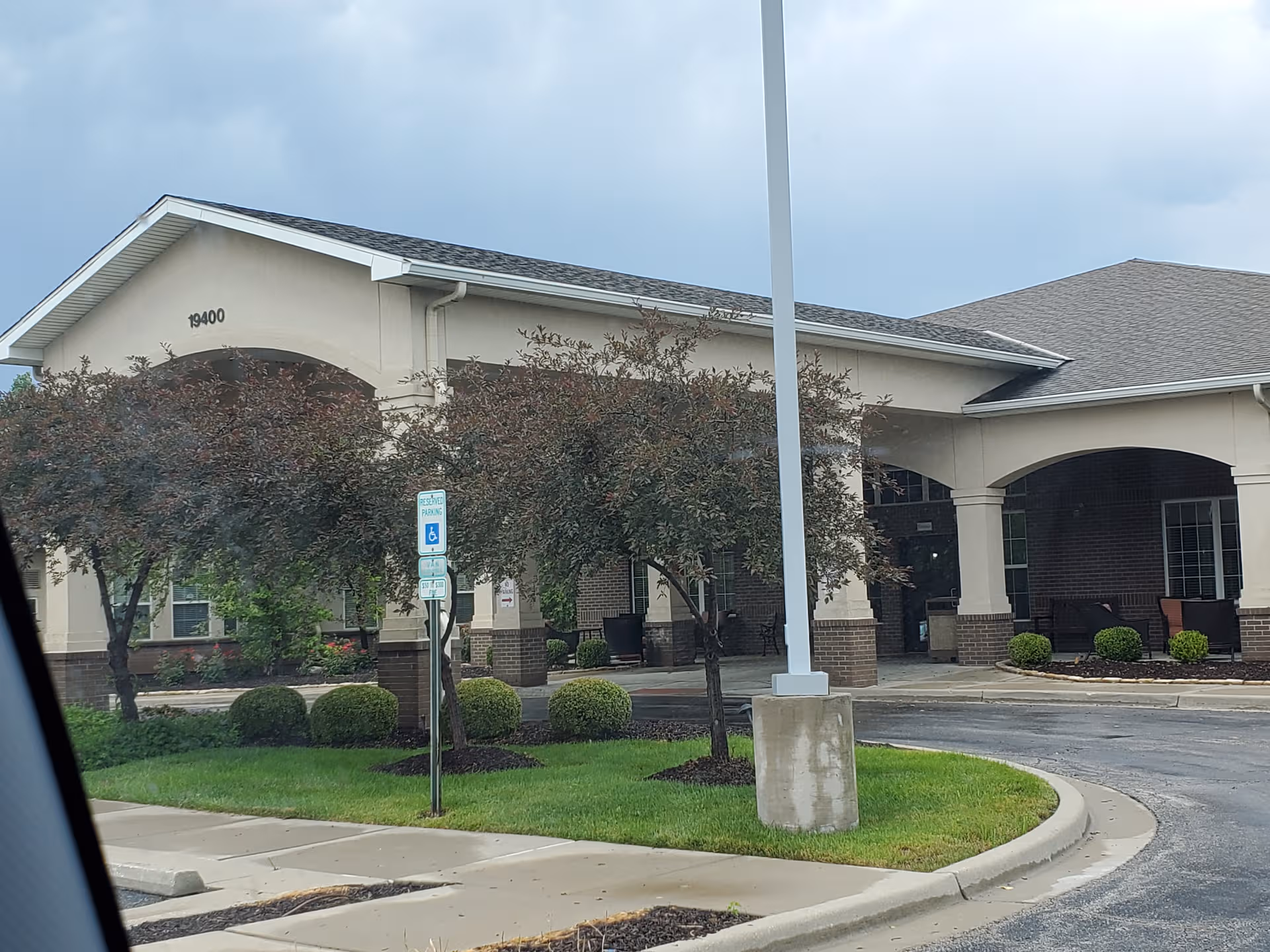Exterior view of Jackson Creek Memory Care entrance with landscaping and parking.