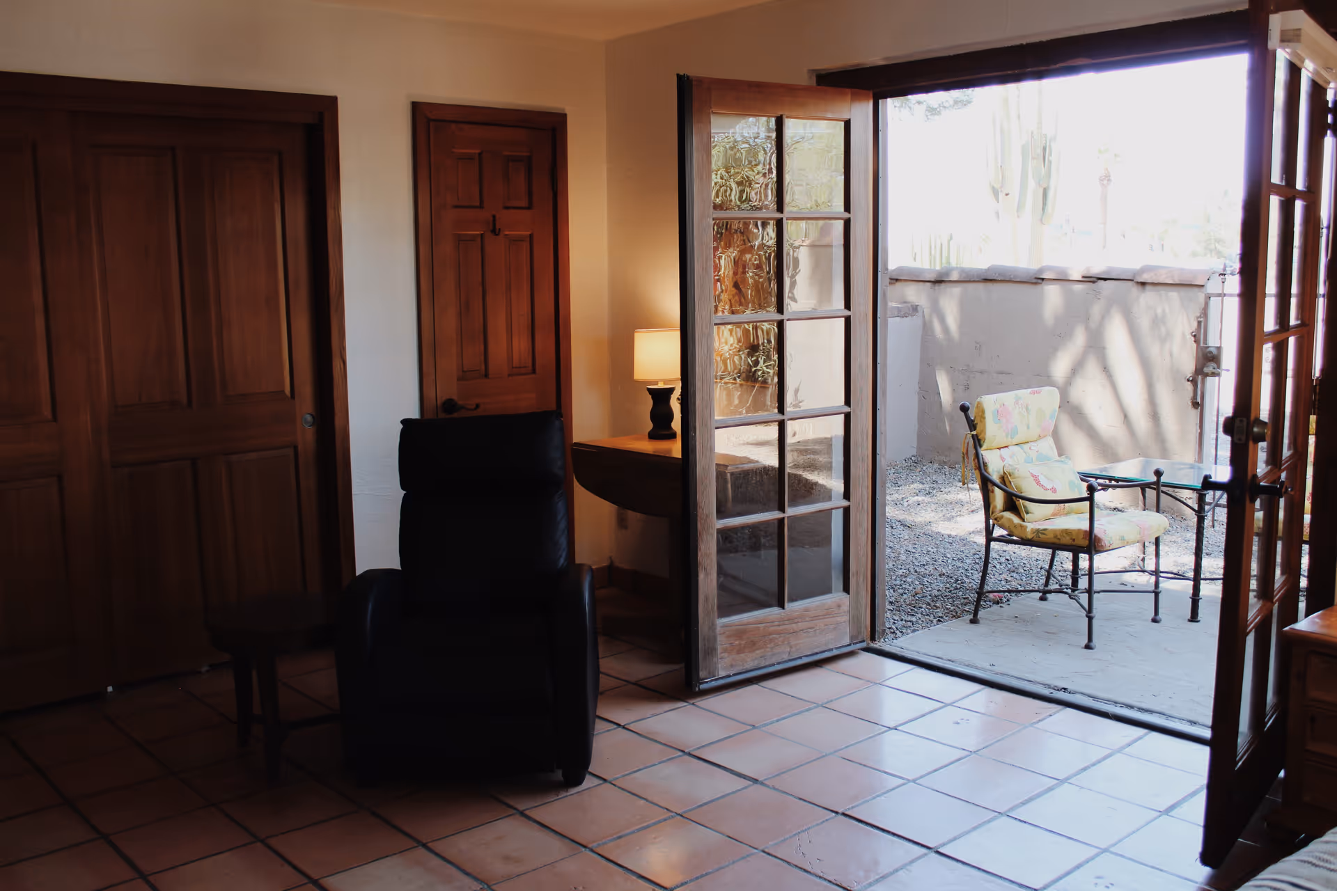 Interior living room with a black recliner and open French doors to a patio.