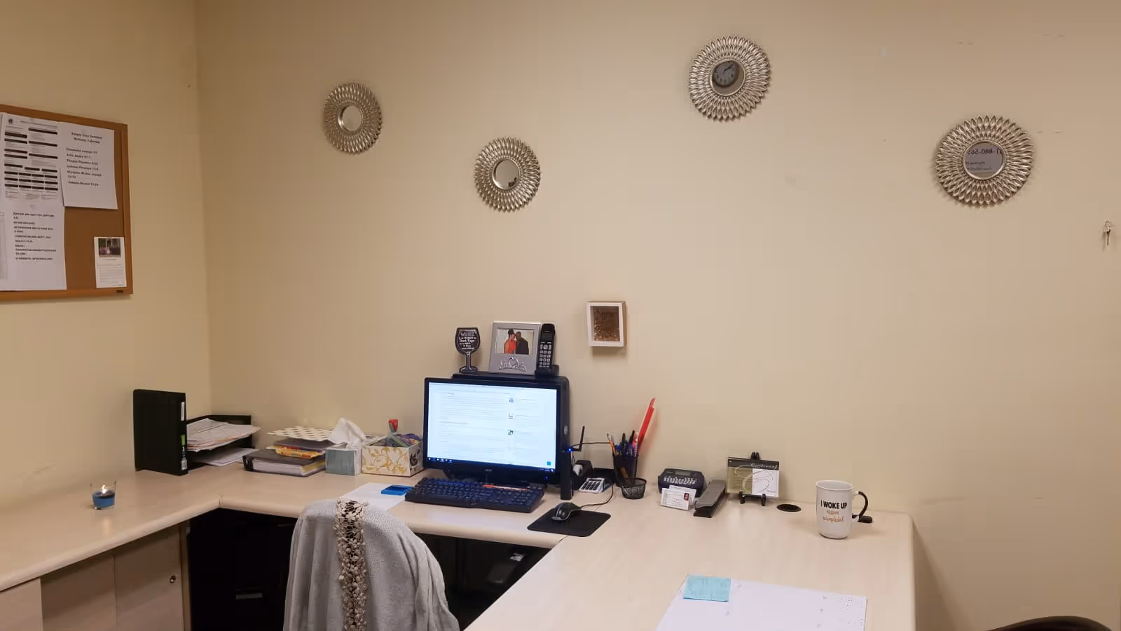 Tidy desk in a Simply Care Services office with computer, papers, and office supplies.