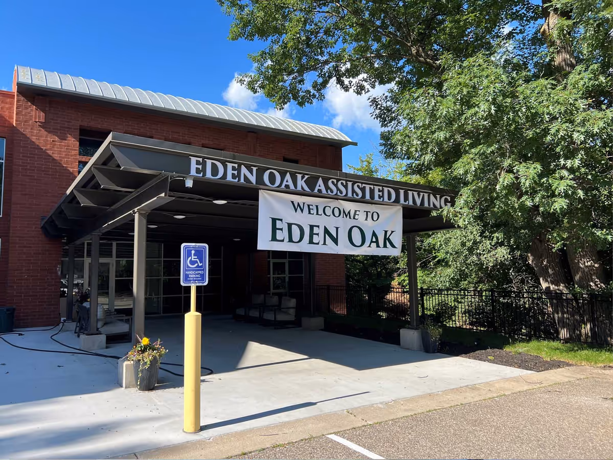 Red brick assisted living facility entry with a Welcome to Eden Oak banner.