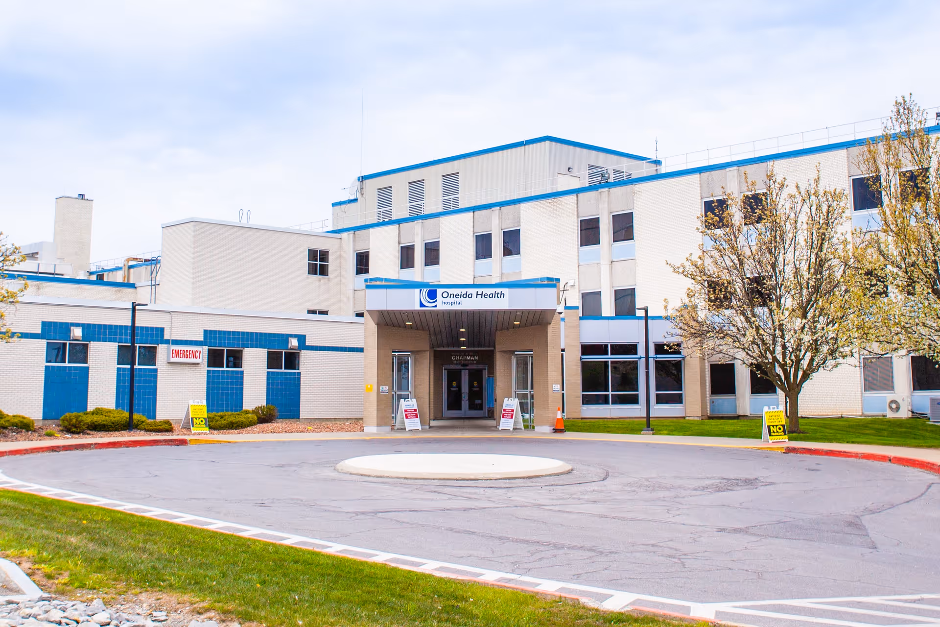 Exterior view of Oneida Health Rehabilitation & Extended Care with entrance, circular driveway, and trees.