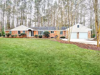 Single-story brick assisted living building with a curved front entrance and well-kept lawn.