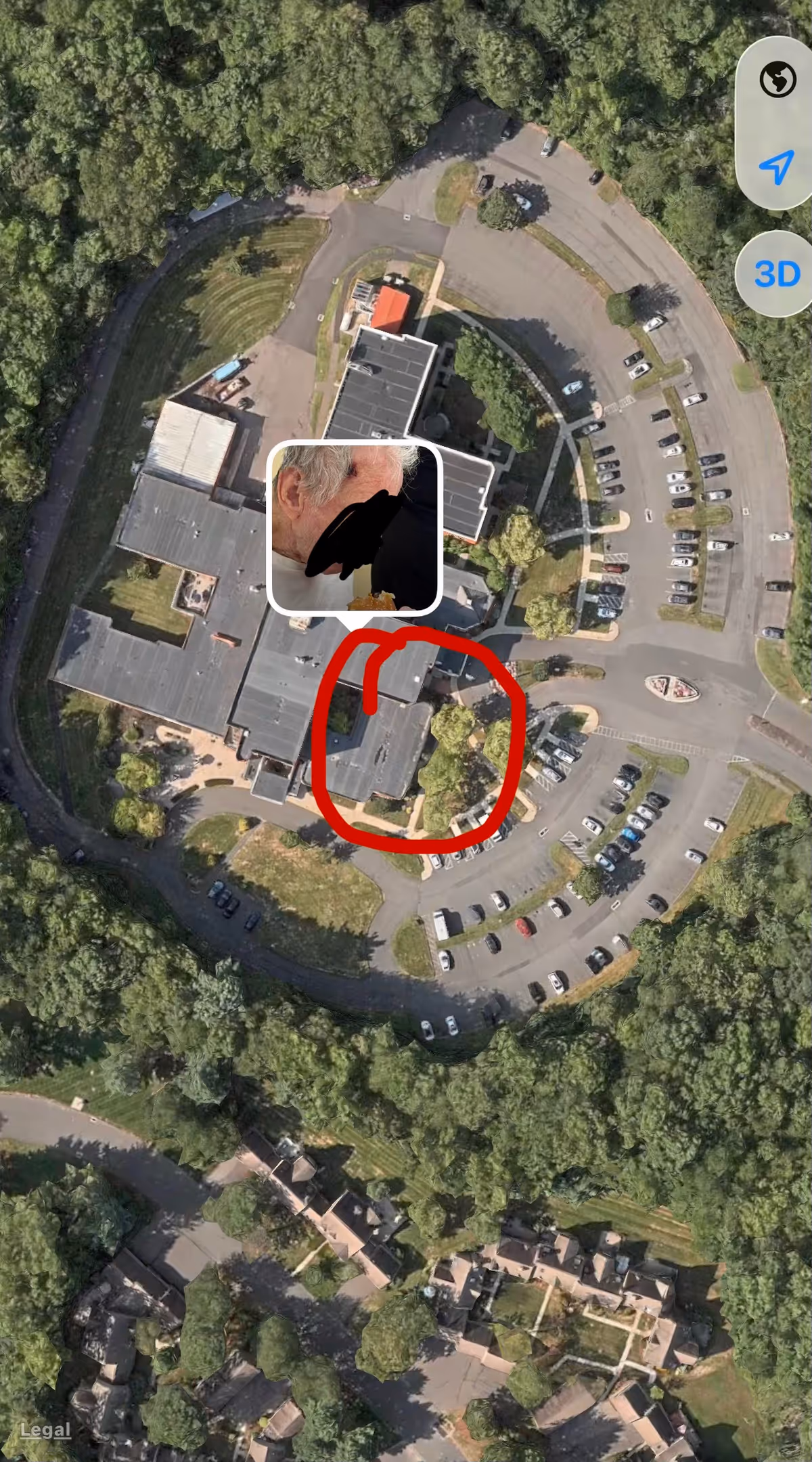 Aerial view of a circular senior living campus with parking and surrounding trees.